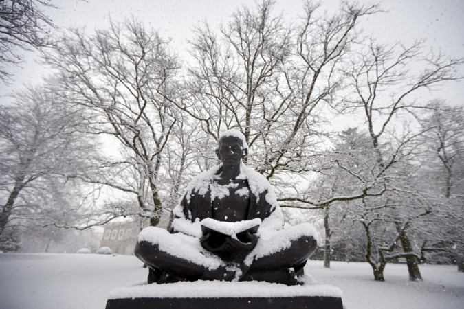 Snow falls on a statue of Mahatma Gandhi in Geneva.