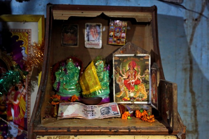 1000 Indian rupee banknotes are seen kept in front of idols and pictures of Hindu deities at a shop on the outskirts of northern city of Kanpur, India November 9, 2016. India rupee