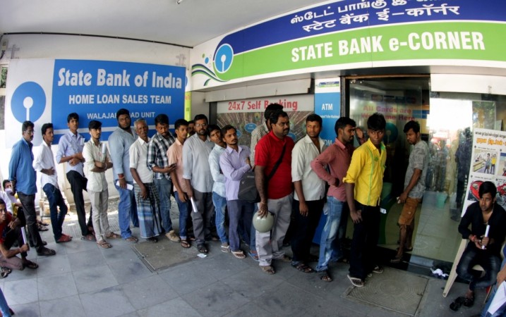 People wait to withdraw money from ATMs People wait to withdraw money from ATMs