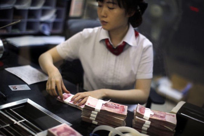 An employee of the Industrial and Commercial Bank of China Ltd (ICBC) counts money at one of the bank's branches at the Shanghai Free Trade Zone in Pudong district, in Shanghai September 24, 2014. china, china economy, china growth rate 6.7 percent, china growth rate 6.7%, xi jinping, indian economy