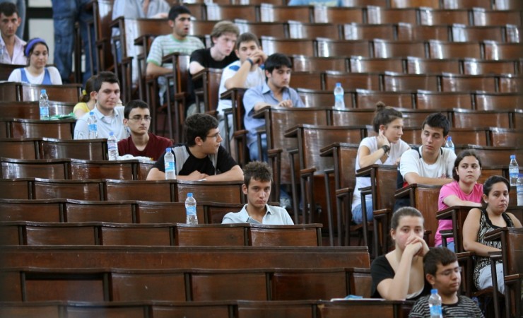 Students take their seats in an amphitheatre prior to an exam. Students writing exams
