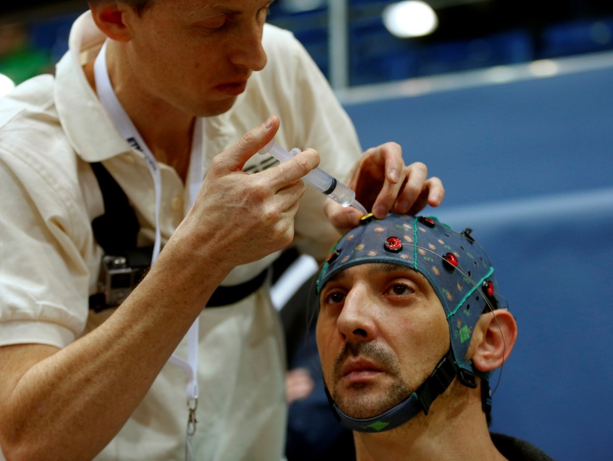 A team member puts contact gel on the cap of Andre Neyron of France before the Brain-Computer Interface Race (BCI) at the Cybathlon Championships in Kloten, Switzerland October 8, 2016.