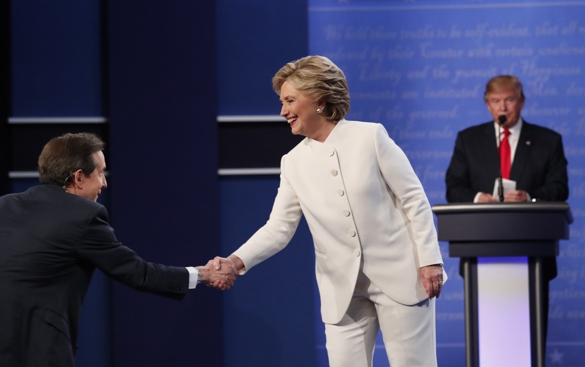 Democratic U.S. presidential nominee Hillary Clinton shakes hands with moderator Chris Wallace (L) as Republican U.S. presidential nominee Donald Trump remains at his podium after the conclusion of their third and final 2016 presidential campaign debate at UNLV in Las Vegas, Nevada, U.S., October 19, 2016.