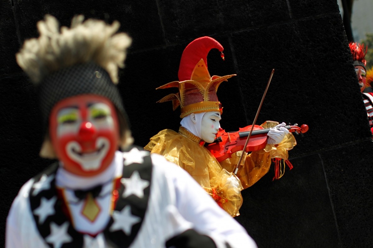 A clown plays the violin during the XXI Convention of Clowns, at the Jimenez Rueda Theatre, in Mexico City, Mexico, October 19, 2016.