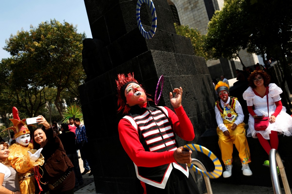 A clown juggles on the street during XXI Convention of Clowns, at the Jimenez Rueda Theatre, in Mexico City, Mexico, October 19, 2016.