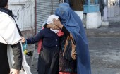 A woman holds her daughter's head as they walk away after a blast near the Pakistani consulate in Jalalabad, Afghanistan on 13 January 2016. Afghan security forces exchanged fire with gunmen barricaded in a house near the Pakistan consulate in the eastern city of Jalalabad on Wednesday after a suicide bomber blew himself up, officials said.