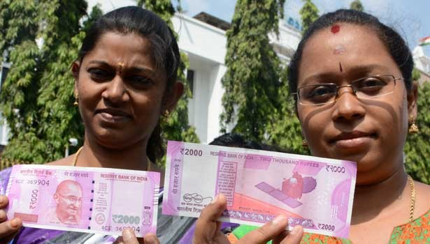 Women pose with the new Rs 2000 note.