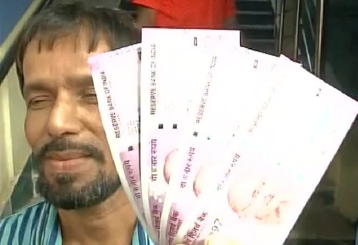 Man poses with the new Rs 2000 note.