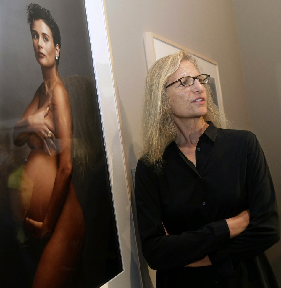 U.S. photographer Annie Leibovitz poses by one of her photographs of U.S. actress Demi Moore during the inauguration of her exhibition 'A Photographer's Life 1990-2005' in Madrid June 18, 2009. Demi Moore