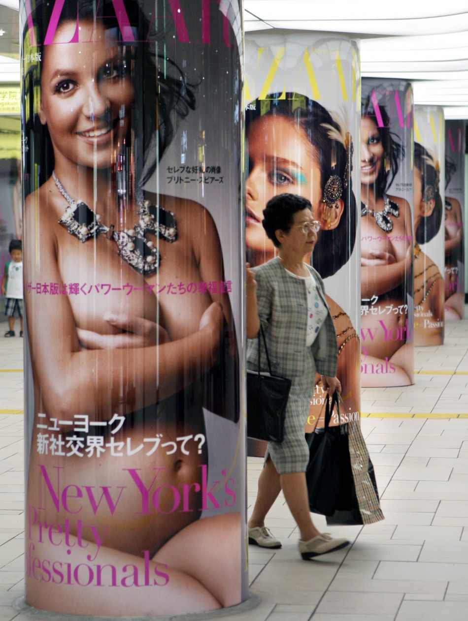 A woman walks past a poster of a pregnant and nude Britney Spears in a subway station in Tokyo August 28, 2006.
Britney Spears