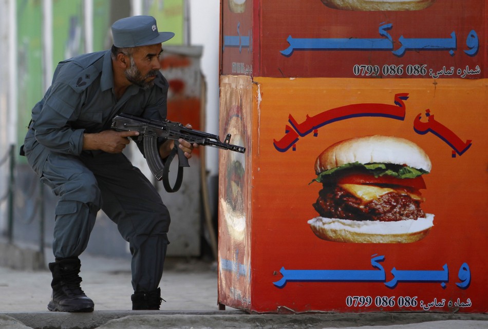 An Afghan policeman takes position at the site of an attack in Kabul. Taliban Attack in Kabul
