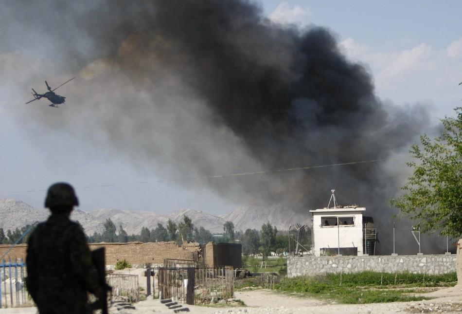 An Afghan National Army soldier keeps watch near the Provincial Reconstruction Team (PRT) as a NATO helicopter flies over the site of an attack in Jalalabad province April 15, 2012. Gunmen launched multiple attacks in the Afghan capital Kabul on Sunday, assaulting Western embassies in the heavily guarded, central diplomatic area and at the parliament in the west, witnesses and officials said Taliban Attack in Kabul