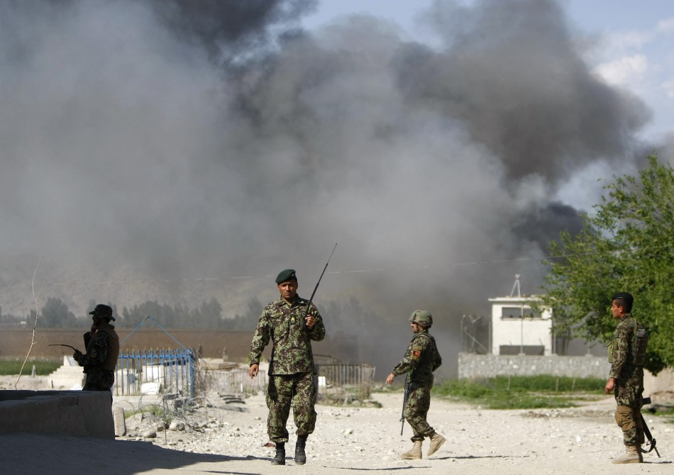 Soldiers from the Afghan National Army keep watch near the Provincial Reconstruction Team (PRT) as smoke rises from the site of an attack in Jalalabad province on 15 April 2012 Taliban Attack in Kabul