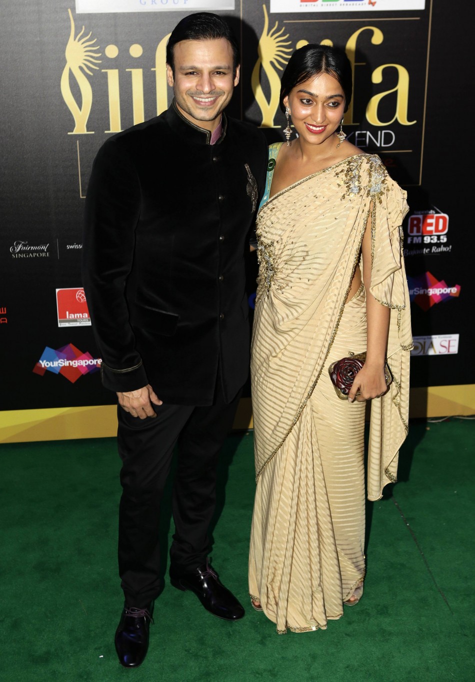 Bollywood actor Vivke Oberoi and wife Priyanka pose for photos on green carpet before IIFA Awards show in Singapore IIFA Awards 2012