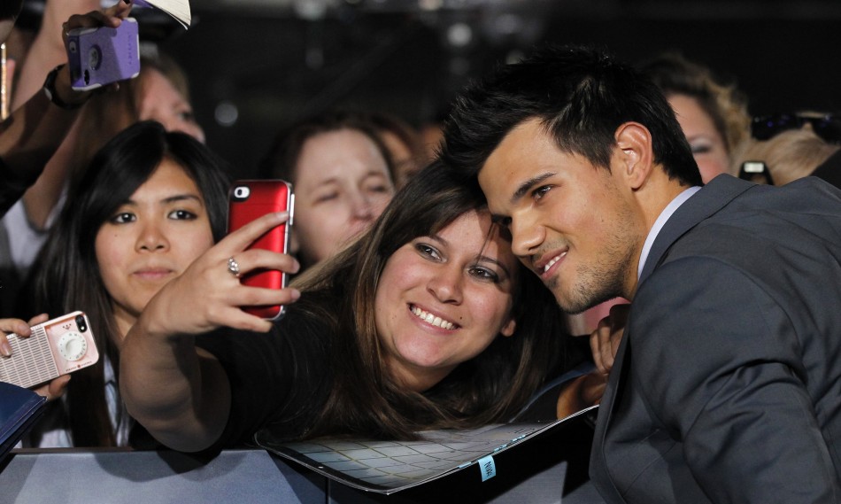 Cast member Lautner poses with a fan at the premiere of Taylor Lautner