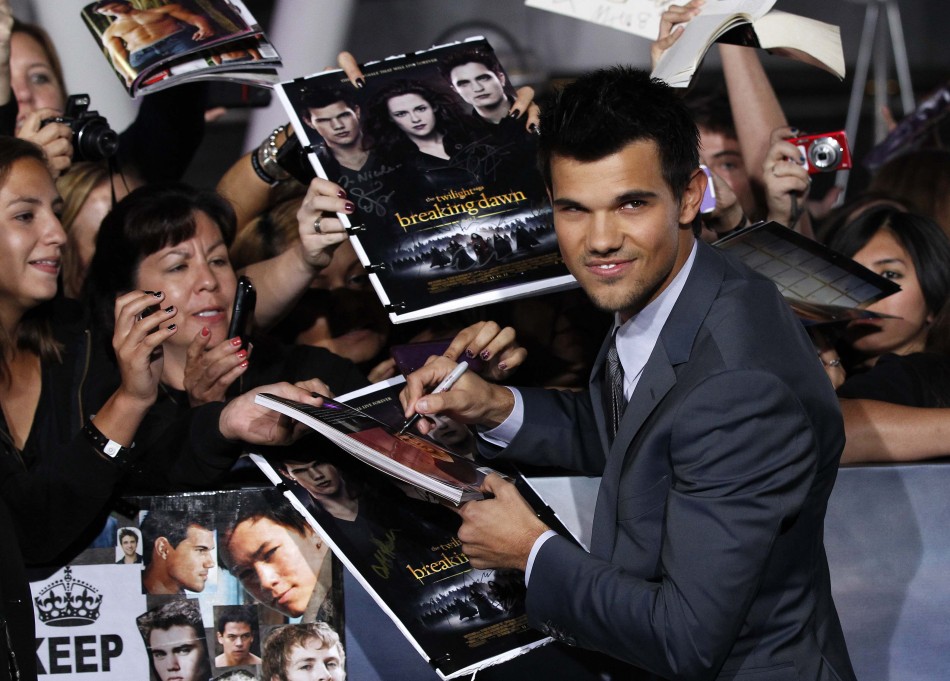Cast member Lautner signs autographs at the premiere of Taylor Lautner