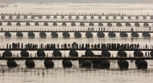 Hindu devotees cross pontoon bridges spanning river Ganges during first Kumbh Mela