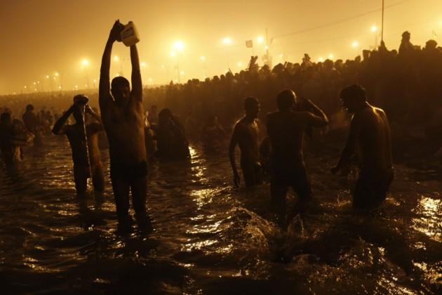 Hindu devotees pray as they attend the first 'Shahi Snan' at the ongoing Kumbh Mela