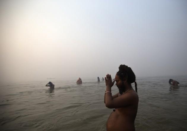 Sadhu or Hindu holy man prays as he takes dip during first Kumbh Mela