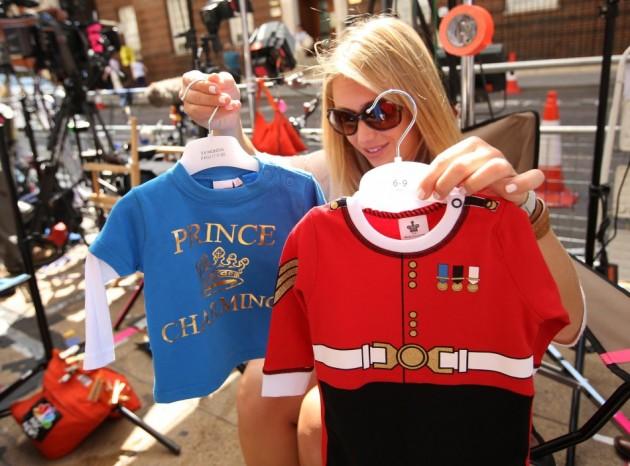 A member of the U.S. media decides which baby clothes to show to the camera outside the Lindo Wing of St Mary's Hospital, where Britain's Catherine, Duchess of Cambridge is due to give birth, in London Royal Baby