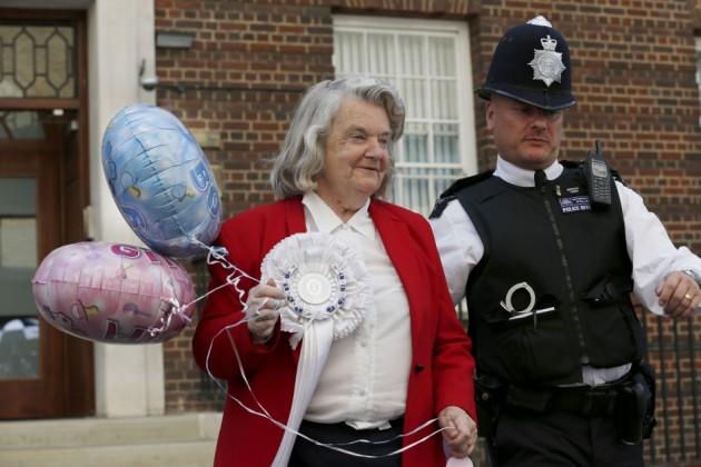 Royalist Magraret Tyler is escorted away after posing for a photograph in front of the Lindo Wing of St Mary's Hospital, where Britain's Catherine, Duchess of Cambridge is due to give birth, in London Royal Fan