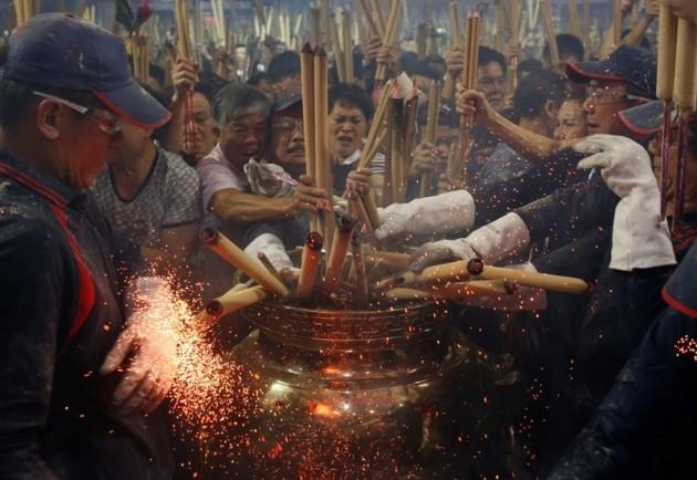People rush to plant the first joss stick of the Chinese New Year at the stroke of midnight at a temple in Singapore early January 31, 2014.REUTERS/Edgar Su Chinese New Year 2014