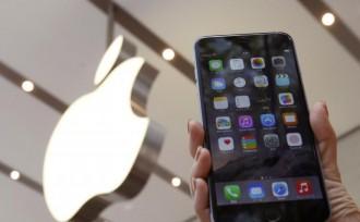 A woman holds up the iPhone 6 Plus at the Apple Store at Tokyo's Omotesando shopping district.