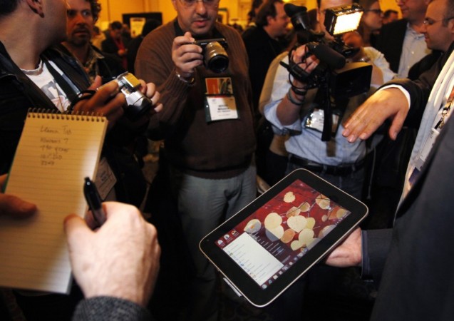 A man displays an unannounced Lenovo tablet computer at a preview of the CES in Las Vegas.