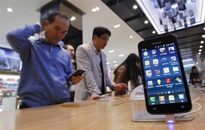 Customers look at Samsung Electronics' Galaxy series smartphones on display at a shop in Seoul