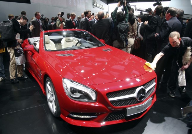 A worker removes fingerprints from the 2013 Mercedes Benz SL on the first press preview day at the North American International Auto Show in Detroit, Michiganon the first press preview day in Detroit, Michigan, January 9, 2012.