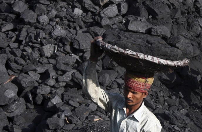 A labourer carries coal in a basket to load it in a truck at a coal store in the northern Indian city of Chandigarh. Labourer