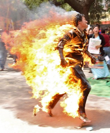 A Tibetan exile runs after setting himself on fire during a protest against the upcoming visit of Chinese President Hu Jintao to India in New Delhi March 26, 2012. Tibetan Protester