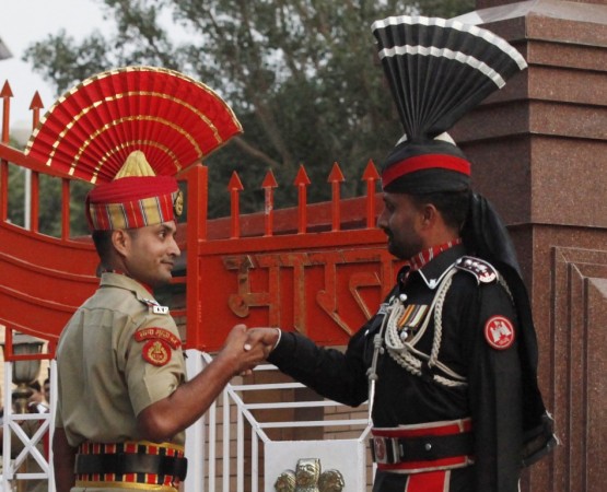 A Pakistani Ranger and an Indian Border Security Force officer shake hands during the daily parade at the Pakistan-India joint check-post at Wagah border