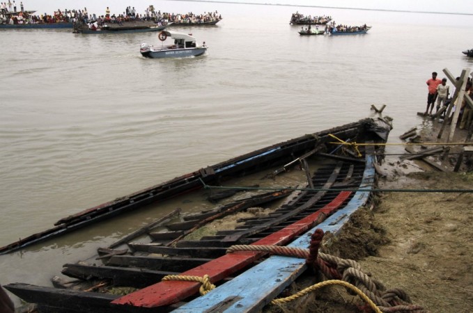 Onlookers and rescue workers look at the damaged boat which was taken on shore after it sank on the Brahmaputra river, at Buraburi village in Dhubri district of the northeastern Indian state of Assam May 1, 2012. Brahmaputra river