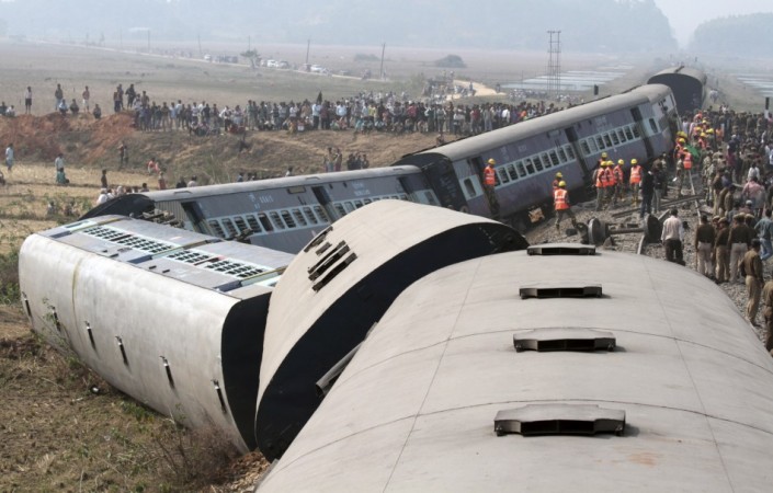 Onlookers and rescue workers gather around the derailed coaches of a passenger train in Bangapara village in February