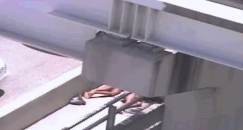 CCTV surveillance shows the two men lying next to the MacArthur Causeway highway in Miami (Image Credit: Screen Grab from Youtube) CCTV surveillance shows the two men lying next to the MacArthur Causeway highway in Miami (Youtube)