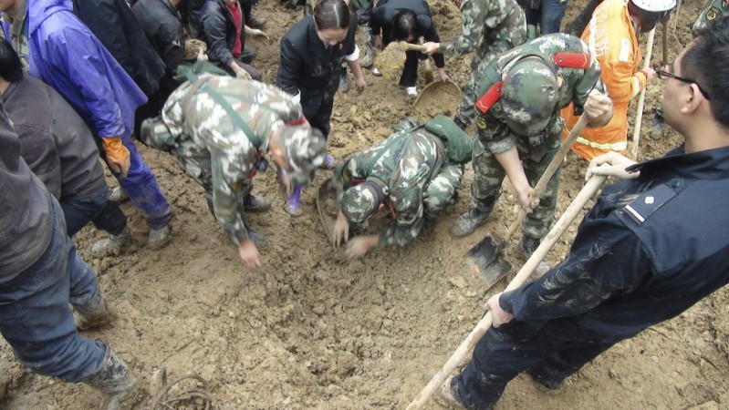 Paramilitary policemen search for victims after a landslide engulfed a building of a primary school at Zhenhe village of Yiliang county, Yunnan province October 4, 2012. China Landslide
