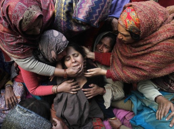 Unidentified women console the wife of Subhash Tomar during his funeral in New Delhi.