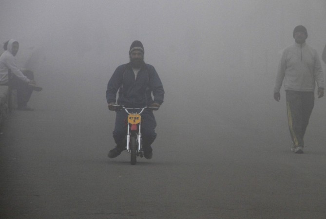 A man rides his mini bike amid dense fog on a cold winter morning in Chandigarh Cold wave in north India