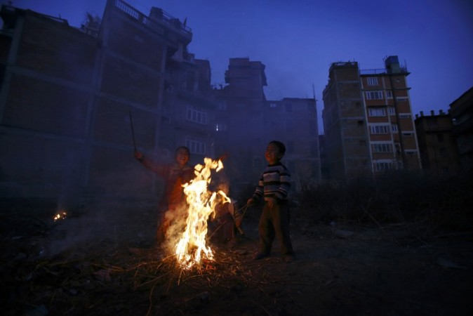 Children play near the fire to keep themselves warm on a cold evening at Kathmandu January 1, 2013. REUTERS/Navesh Chitrakar Cold wave in north India
