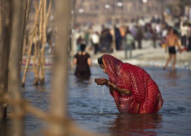 A Hindu woman prays as she takes a holy dip in the waters of the Ganges river ahead of the Kumbh Mela