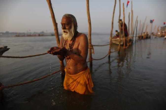 Hindu devotee prays as they take a holy dip in the waters of the Ganges river ahead of the Kumbh Mela