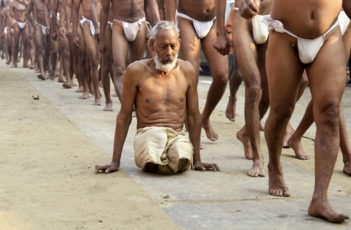 A physically disabled Naga Sadhu or a Hindu holyman arrives with fellow Sadhus to attend Dikasha, a ritual on the banks of the river Ganges, during the ongoing Newly initiated Naga Sadhus