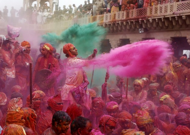 People throw coloured powder as they celebrate "Lathmar Holi" at Nandgaon village in the northern Indian state of Uttar Pradesh, March 22, 2013. In a Holi tradition unique to Nandgaon and Barsana villages, men sing provocative songs to gain the