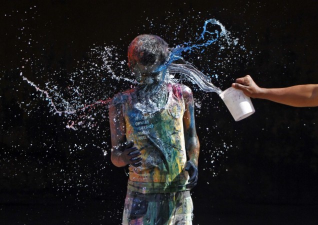 A boy smeared with colours reacts as another boy pours water on him during Holi celebrations in the southern Indian city of Chennai Holi 2013