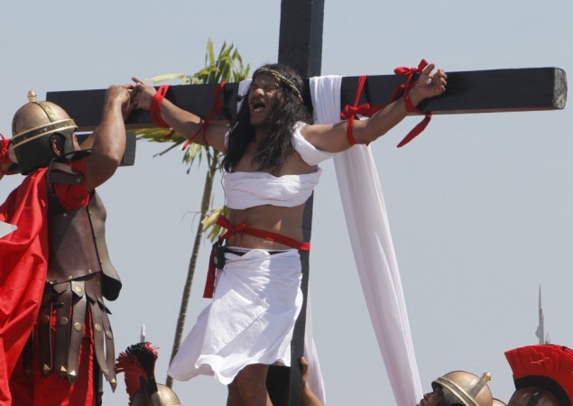 Enaje, who potrays Jesus Christ, screams while a man playing a Roman soldier pulls out a nail from his palm during a Good Friday crucifixion re-enactment in San Pedro Cutud Good Friday