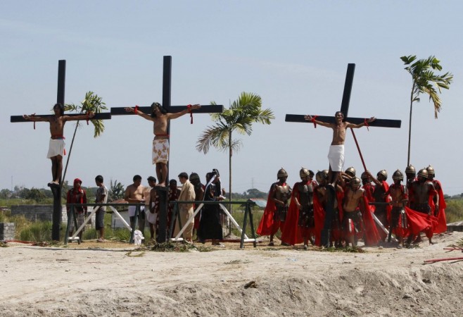 Penitents hang on wooden crosses after they were nailed to them during a Good Friday crucifixion re-enactment in San Pedro Cutud Good Friday