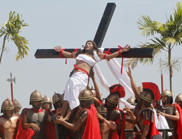 Enaje, who is portraying Jesus Christ, is raised on a wooden cross by a group of men playing Roman soldiers during a Good Friday crucifixion re-enactment in San Pedro Cutud Good Friday