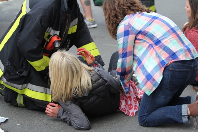 An injured woman is attended to at the scene of an explosion at the Boston Marathon Boston Marathon