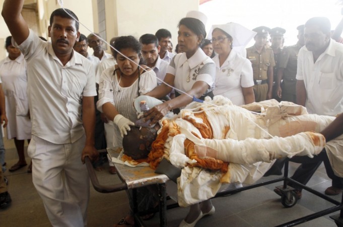 Sri Lankan Buddhist monk Bowatte Indaratane Thera is tended by medical personnel as he is carried into a hospital on a stretcher in Colombo May 24, 2013. According to local media, the monk had set himself on fire in a form of protest against the slaughter of cattle slaughter. REUTERS/Stringer Buddhist monk